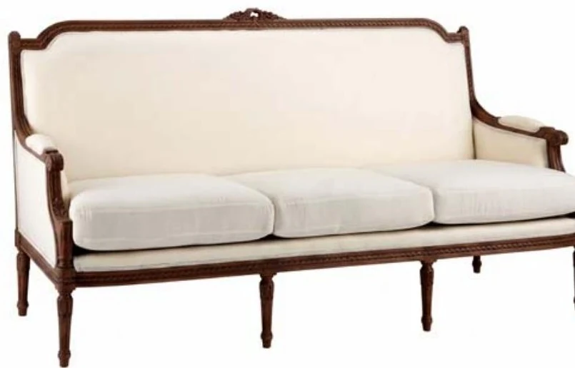 Classic sofa upholstered in cream with a carved walnut frame